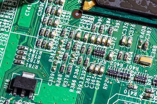 wet digital circuit board with microprocessors and components, closeup full-frame macro background