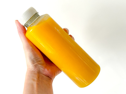 Plastic orange sports drink bottle isolated on white. Vertical.