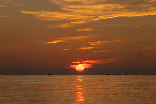 Colorful sunset  with sail boats docked in harbor.