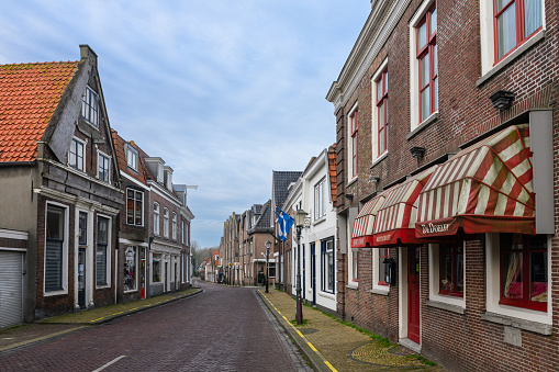 In Muiden, Netherlands the buildings along this street are occupied with a variety of small business not yet open on an early winter morning.