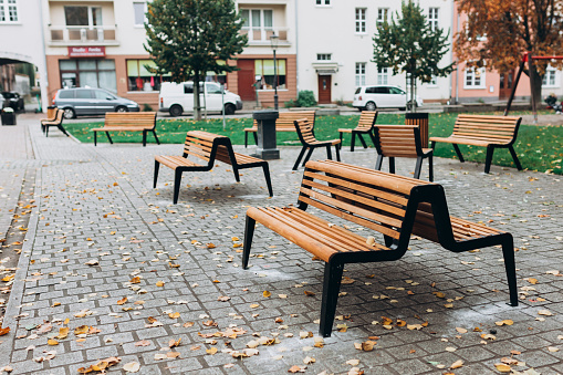 Modern wooden benches standing of the city park. Place for rest of citizens on the street.
