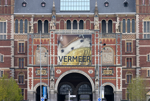 Amsterdam, Netherlands - April 21, 2023: Facade of the Rijksmuseum Dutch national museum with a banner advertising a special exhibition of Vermeers paintings