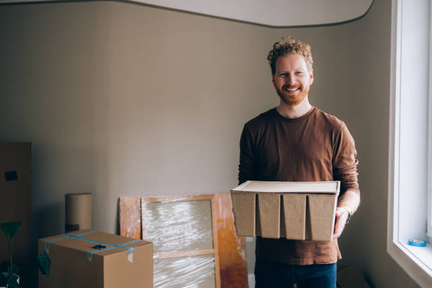 istock Move-In Essentials: Man Holds Key Possessions in a Box, a Portrait 1845490203