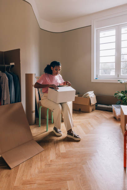istock New Beginnings: Woman Unpacking Boxes in Fresh Apartment 1845514677