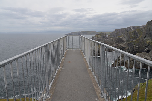 Walk way over the sea from cliffs looking over the sea and sky at the coast of Co Kerry Ireland