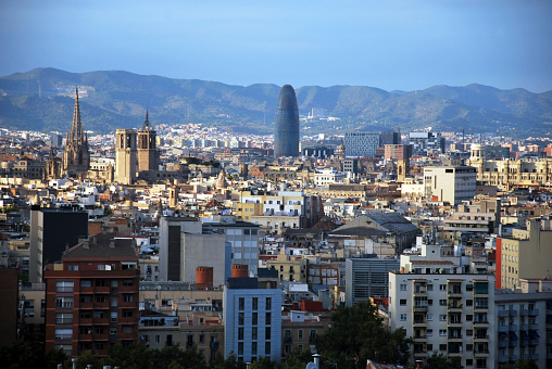 The majestic skyline of Barcelona, cradled by the sweeping Collserola mountain range, unveils a tapestry where iconic structures rise, merging urban splendor with nature's protective embrace.