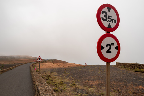 Traffic signs at Mirador del Rio in the fog, Lanzarote, Spain
