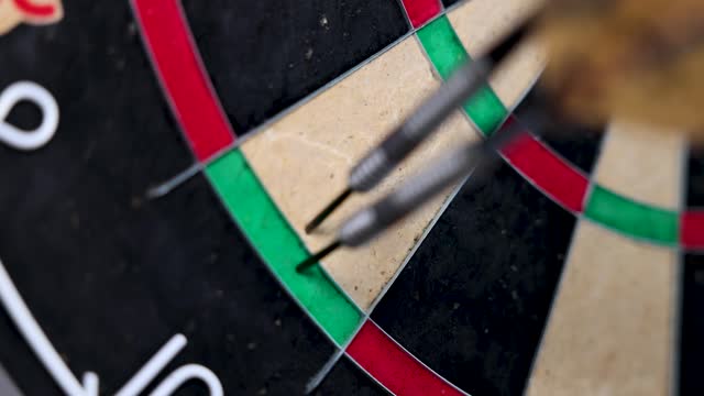 A dart is thrown to complete a double out at double 16. Slow Motion.