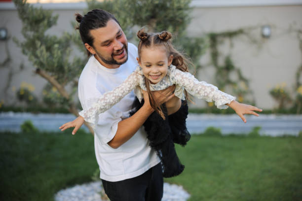 istock Happy little girl playing outside with her dad 1845634749