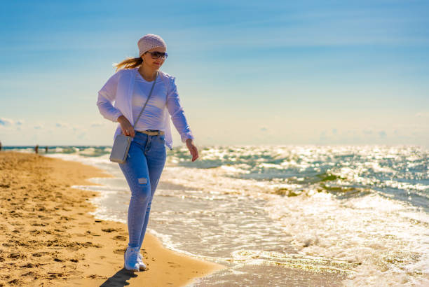 Beautiful woman walking on sunny beach