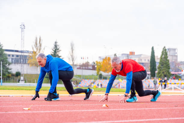 istock Senior man in starting pose in a running athletic track 1845649958