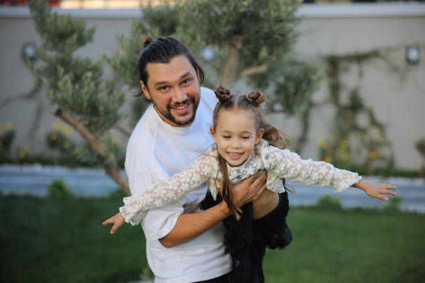 istock Happy little girl playing outside with her dad 1845652585