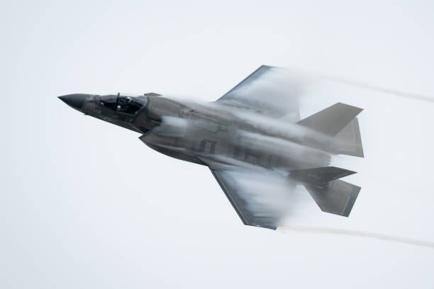 F-35 Lightning II aircraft in full afterburner banking thru clouds causing visible water vapor on wings and fuselage. Aircraft performing flying tricks. Photo taken on 9/21/23 at the Miramar Airshow in San Diego California. thrust stock pictures, royalty-free photos & images