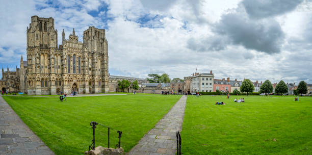 panorama of wells cathedral west front and cathedral green in wells, somerset, uk - somerset west imagens e fotografias de stock