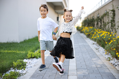 Happy, black kids running in garden and play game together outdoor at home. Children in backyard, excited and race or funny sister chase brother, bonding and laughing for freedom or energy