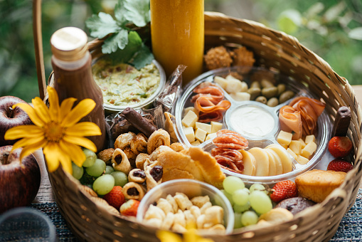 High angle view of an assortment of delicious food sitting in a basket on a dining table outsid eon a patio in summer