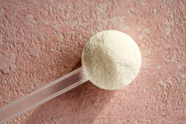 istock White collagen powder in a plastic scoop on pink background 1845722587