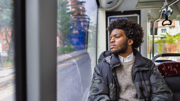 istock Pensive young man Black ethnicity looking through window, while commuting with a public bus 1845728957