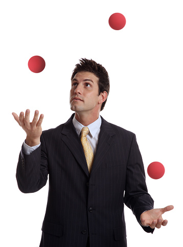 This is a conceptual photo relating to juggling work within your business. The businessman is isolated on a white background.There are similar images in the lightbox below: