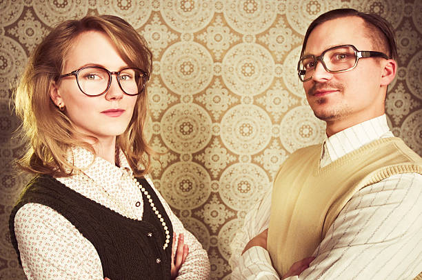 Young co-workers in the office. Authentic vintage wallpaper on background (from 60's)