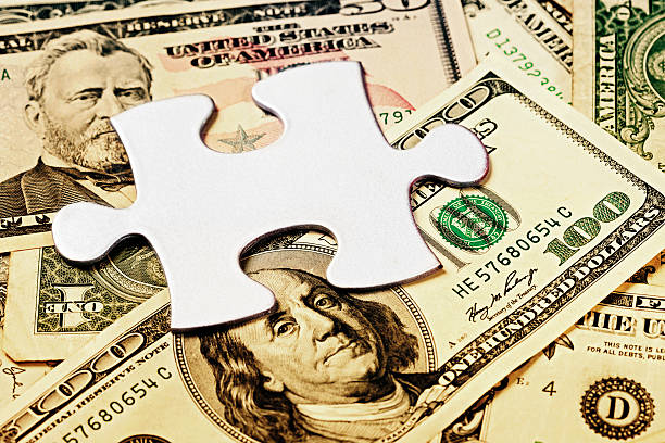 istock Financial confusion or problem:  jigsaw piece on sepia-toned US dollars 184591836