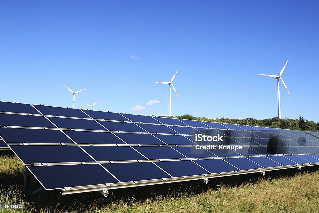 Windturbinen hinter dem Gebiet der solar-panels unter klarem Himmel - Lizenzfrei Ausrüstung und Geräte Stock-Foto