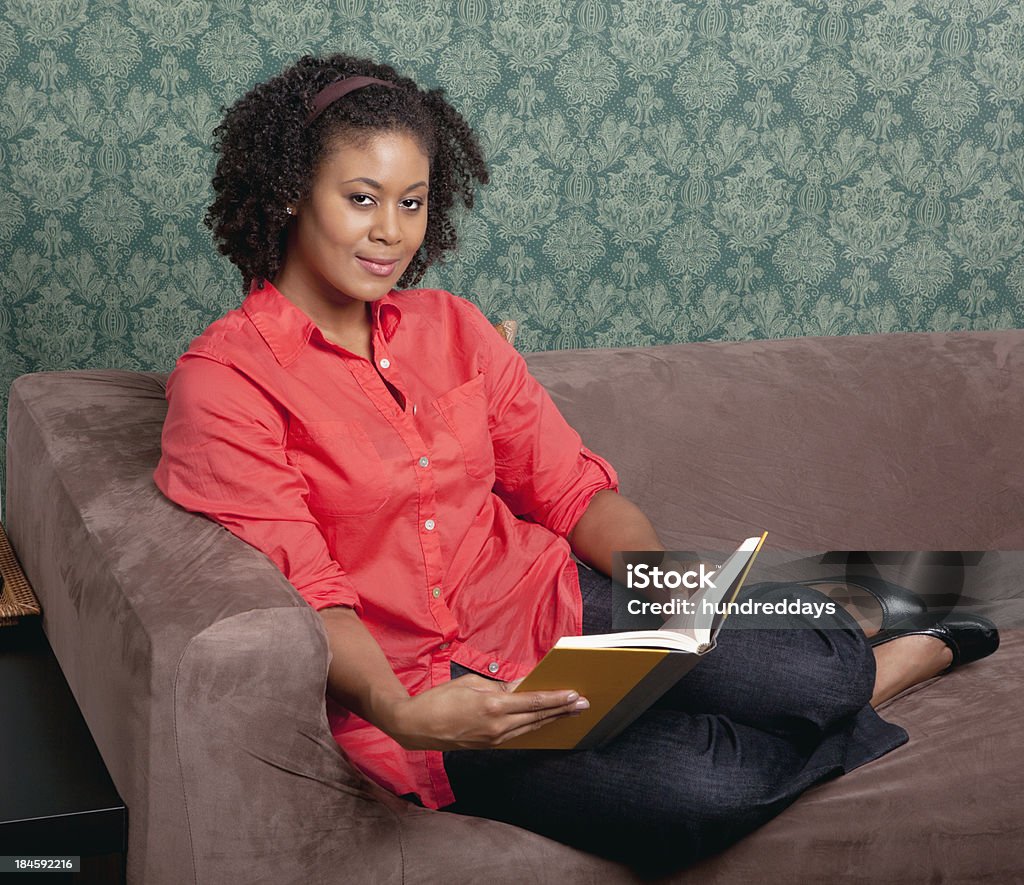 Relaxed woman with book on couch Portrait of relaxed woman with book sitting on couch 30-39 Years Stock Photo