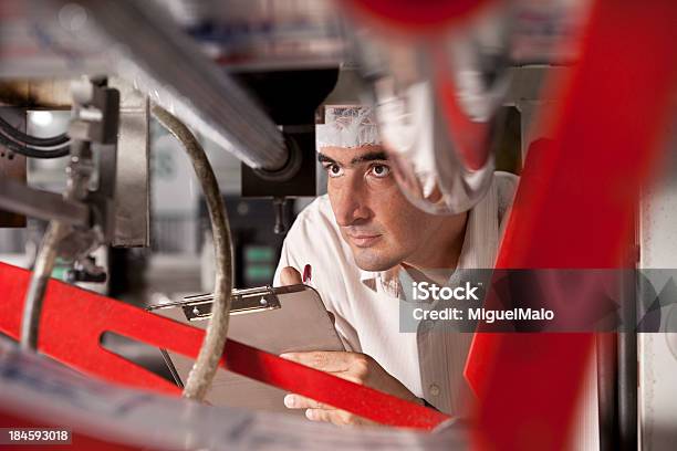 Hombre Con Portapapeles Mirando A Través De La Máquina Foto de stock y más banco de imágenes de Fábrica