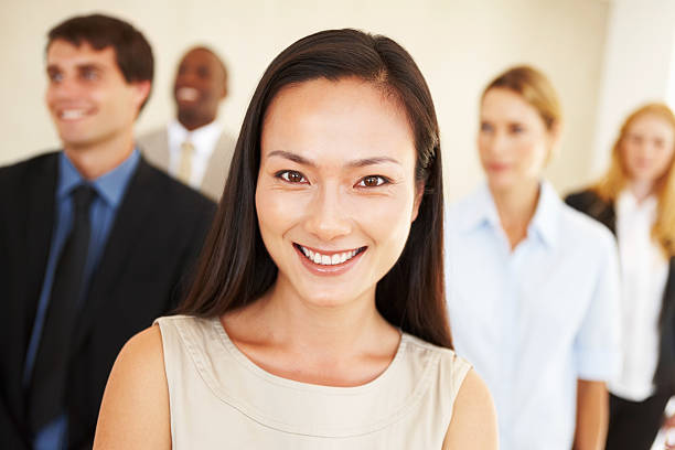 istock Asian business woman smiling with executives 184593089