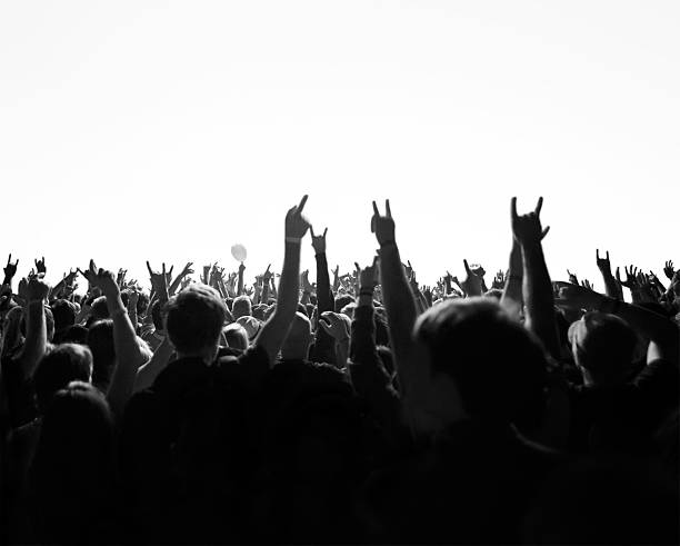 Concert crowd Crowd cheering and watching a band on stage, blinded by stage lights. rock music stock pictures, royalty-free photos & images