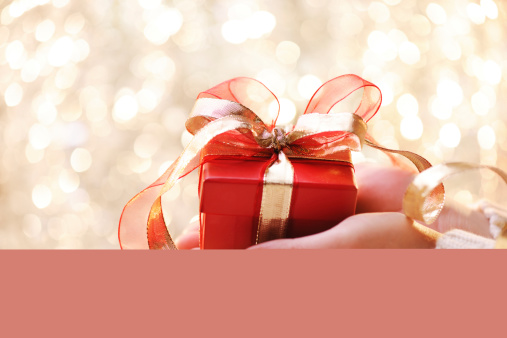 Giving a christmas present with illuminated background-shallow dof- XXXL Image