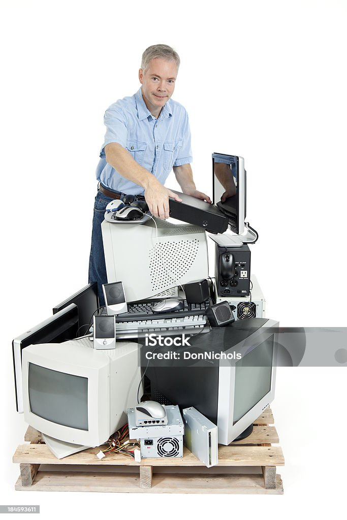 Man Recycling Electronics Man adding to a pile of obsolete computer and electronics equipment for recycling. Isolated on white.Please also see: Electronics Industry Stock Photo