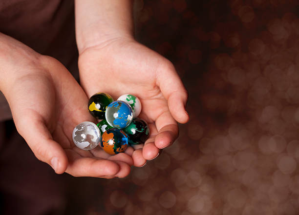 Youth Hands Holding Earth Marbles
