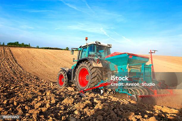 Blue Tractor Sowing In Field Stock Photo - Download Image Now - Plowing, Machinery, Farmer