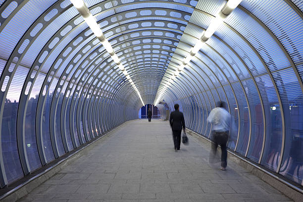 istock Business Commuters Rushing in Glass Walkway at Dusk 184594830