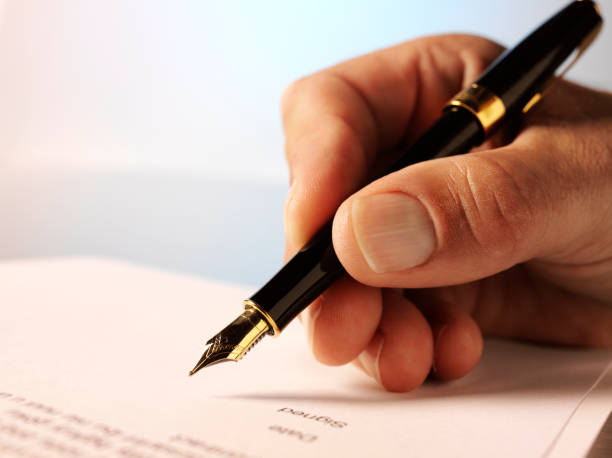 istock Holding a Pen and Contract Signing 184595582