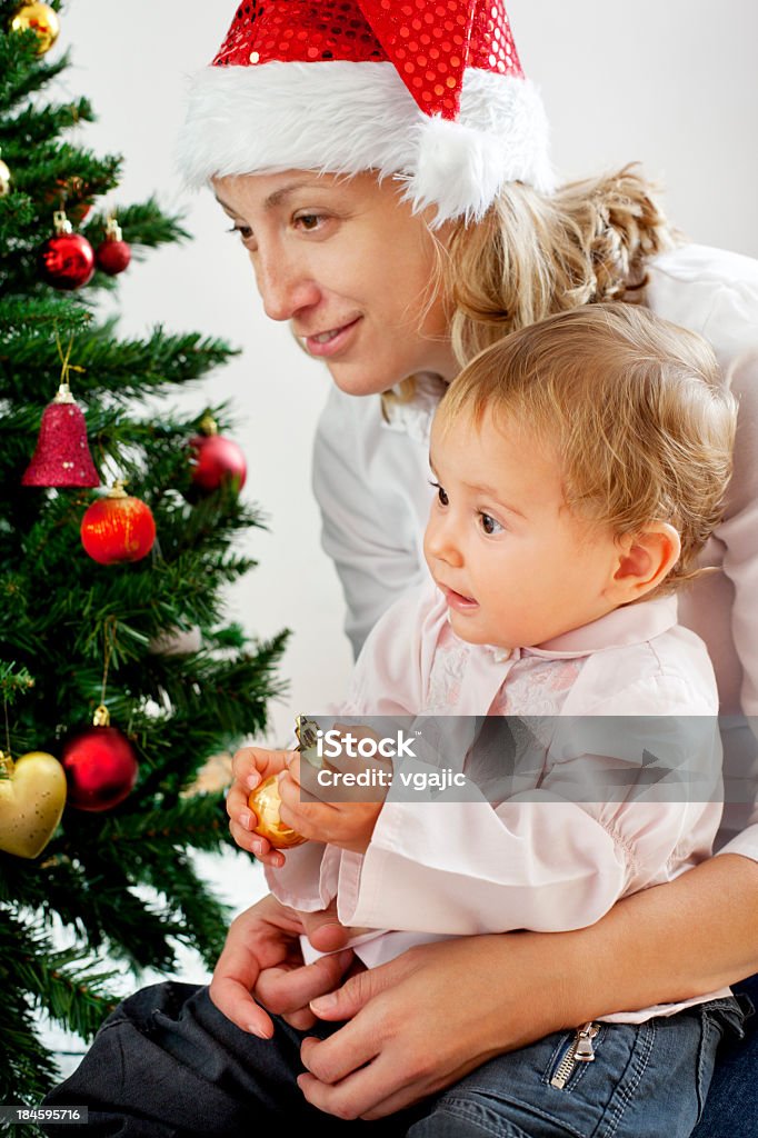 Mother with her baby daughter near Christmas Tree Portrait of an mother holding her baby girl daughter near Christmas Tree 35-39 Years Stock Photo
