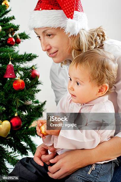 Mother With Her Baby Daughter Near Christmas Tree Stock Photo - Download Image Now - 35-39 Years, 6-11 Months, Adult