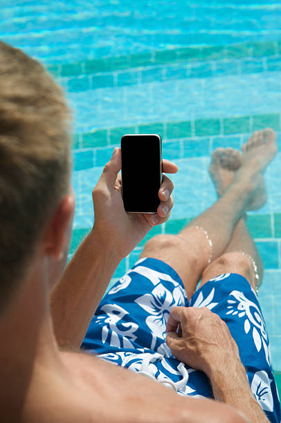 istock Man Relaxing in Swimming Pool with Smartphone Mobile Phone 184595811