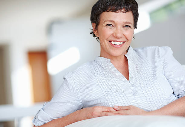 istock Smiling mature woman sitting on couch 184596056