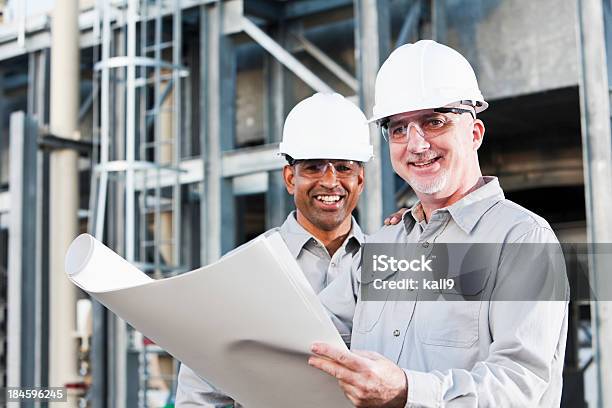 Multirracial Engenheiros Industrial Ler Planos No Local - Fotografias de stock e mais imagens de Engenheiro