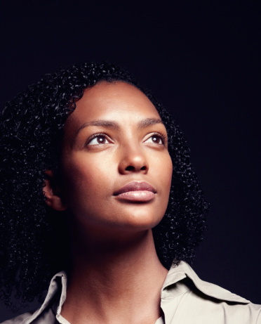 Closeup of African American woman looking away while isolated on black