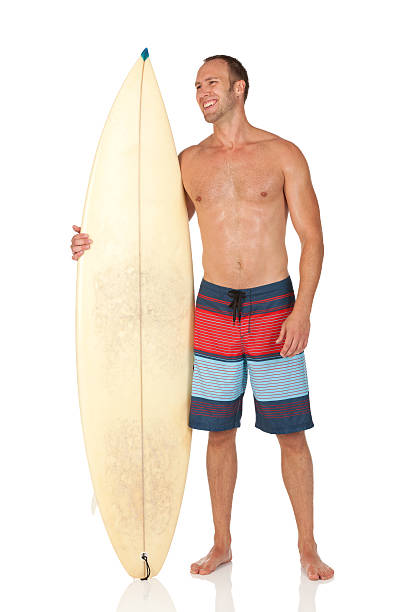 человек стоят с доска для сёрфинга - swimming shorts surfing male full length стоковые фото и изображения