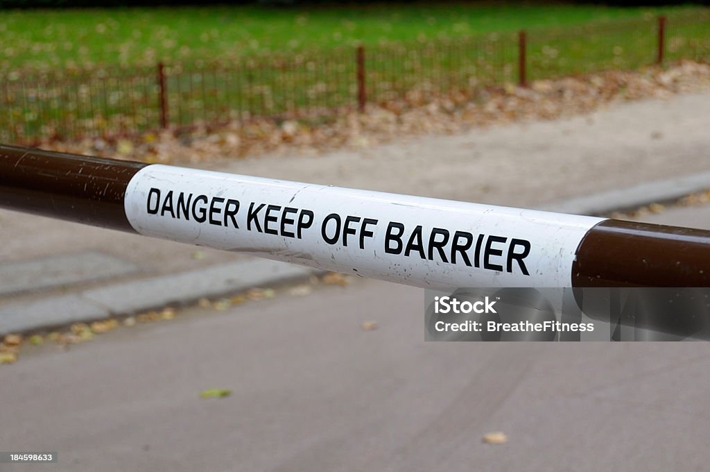 Danger Keep Off Barrier A sign on a barrier blocking a road telling people to keep off the barrier. Boundary Stock Photo