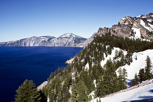 Crater Lake and Garfield Peak Crater Lake exists in the blown-out caldera of a once mighty volcano known as Mount Mazama. This view of the lake was taken from the Rim Trail in Crater Lake National Park, Oregon, USA. jeff goulden crater lake national park stock pictures, royalty-free photos & images