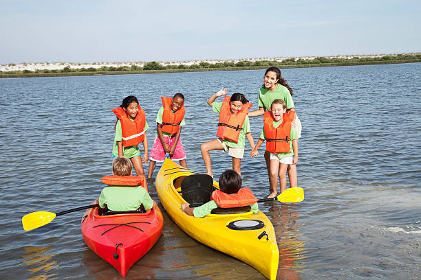 ajudante de colônia de férias de verão e crianças com caiaques - summer camp child teenager kayak - fotografias e filmes do acervo