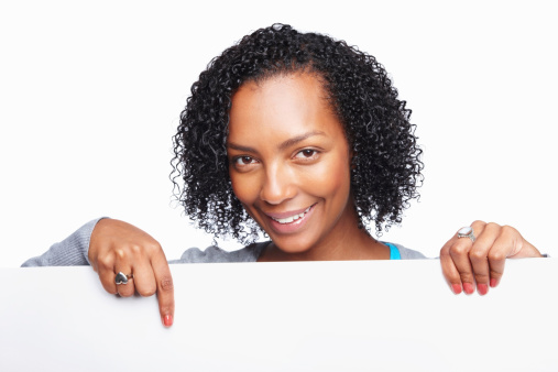 Smiling African American woman pointing at a blank billboard