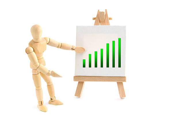 istock Wooden mannequin pointing with hand on business graph 184600476