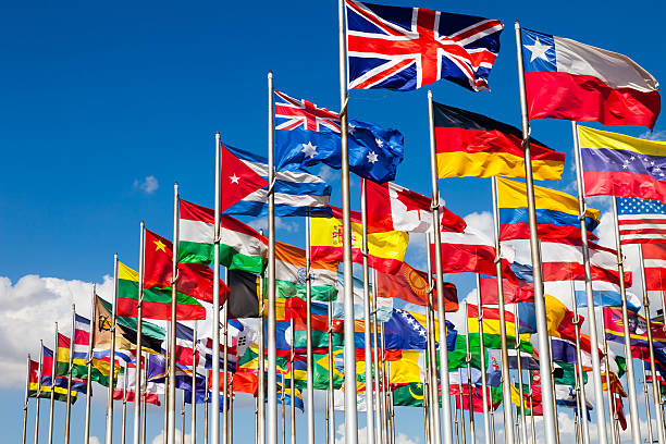 International flags Group of flags of many different nations against blue sky and infront of a convention center. national flag photos stock pictures, royalty-free photos & images