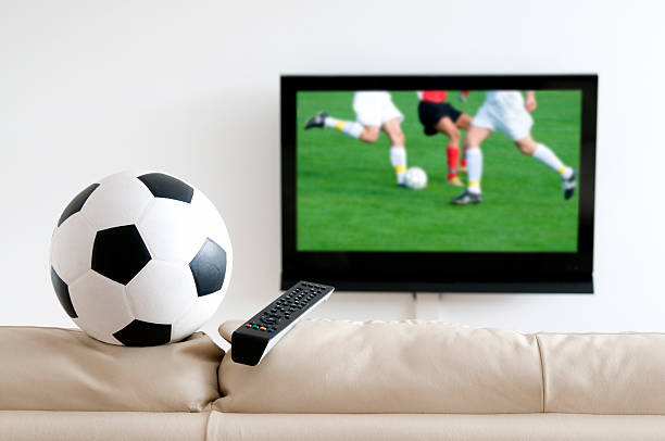 istock Watching soccer on tv with ball on the sofa 184601472
